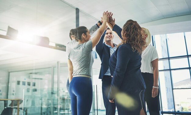 Colegas de negocios dando un "high five" en la oficina