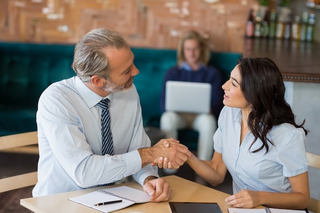 Colegas de negocios dándose la mano después de una reunión exitosa