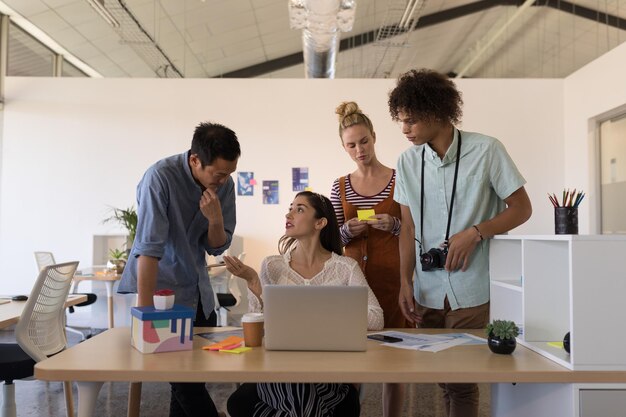 Foto colegas de negocios discutiendo sobre la computadora portátil en la oficina