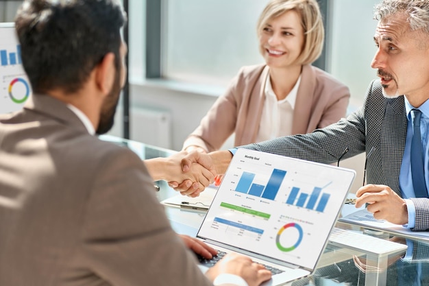 Colegas de negocios felices dándose la mano de cerca