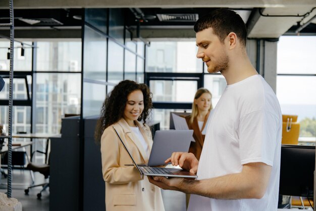 Foto colegas de negocios felices usando una computadora portátil discutiendo la idea