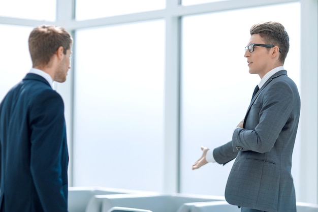 Colegas de negocios hablando de pie en la oficina entre semana