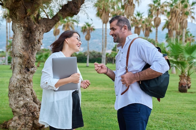 Colegas de negocios de mediana edad hablando en el parque