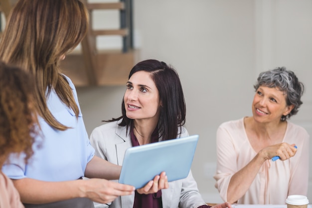 Colegas de negocios mujeres discutiendo sobre tableta digital