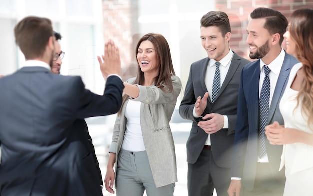 Los colegas de negocios sonrientes se dan unos cinco