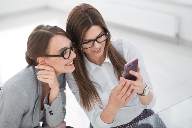 Los colegas de negocios toman selfies sentados en Deskphoto con espacio de texto