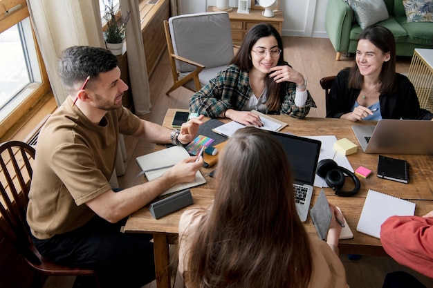 Foto colegas que participan en una sesión de estudio usando cuadernos y una computadora portátil