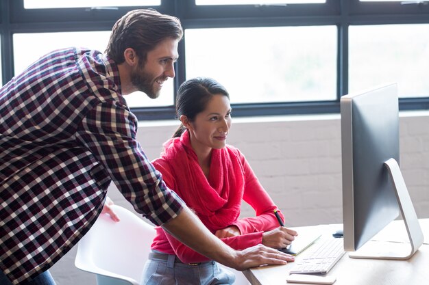 Colegas que trabajan en la computadora en la oficina