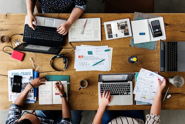 Colegas que trabajan juntos en un escritorio en computadoras portátiles