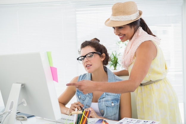 Colegas que usan la computadora y señalando la pantalla