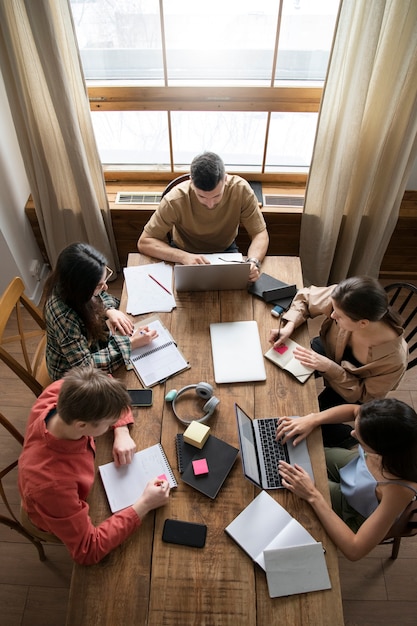 Foto colegas que usan computadoras portátiles y portátiles para aprender en una sesión de estudio