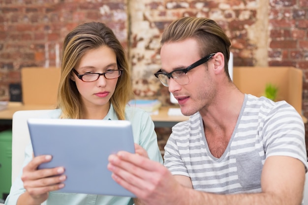 Colegas que usan la tableta digital en la oficina