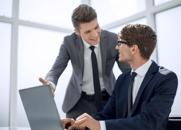 Colegas sorridentes olhando para a tela do laptop office dias da semana