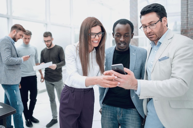 Colegas sorridentes olhando para a tela do smartphone