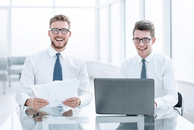 Colegas sorridentes sentados na mesa