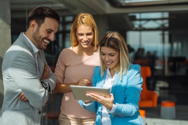 Colegas trabajando juntos en una tableta en una oficina