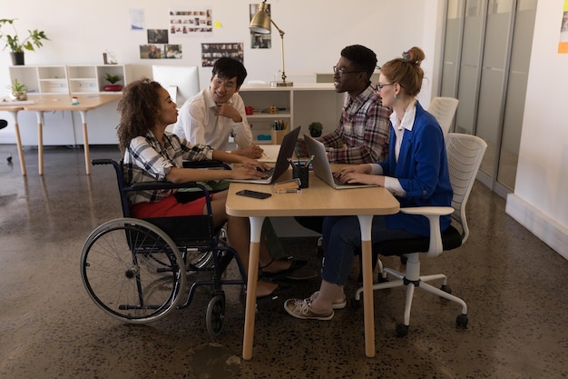 Colegas de trabajo interactuando entre sí en la oficina