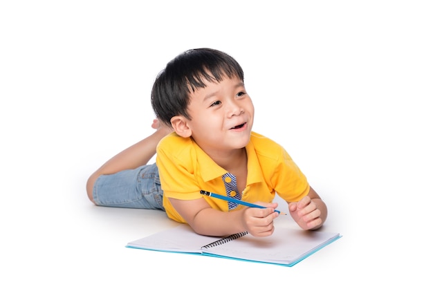 El colegial acostado y escribiendo en el cuaderno.