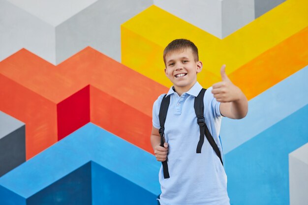 Foto colegial alegre gesticulando pulgar hacia arriba