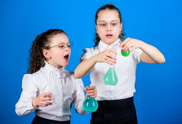 Colegial com líquidos químicos coloridos Conceito de educação Medidas de segurança Estudo de criança pequena Aula de química Divertindo-se com a química Experiência educativa Diversão em química Dia do conhecimento