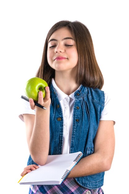 Colegial com notebook e apple em fundo branco.