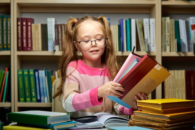 colegial com pilha de livros na biblioteca, pronta para obter novos conhecimentos, se preparando para o exame, fazer a lição de casa