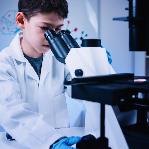 Colegial de educación científica con microscopio de laboratorio