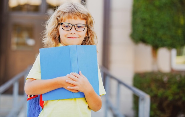 Colegial emocionado con el libro en la escuela