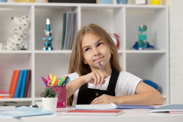 Colegial escrevendo garota da escola com notebook de volta à escola adolescente pronta para estudar