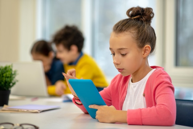 Colegial falando sério olhando para a tela do tablet