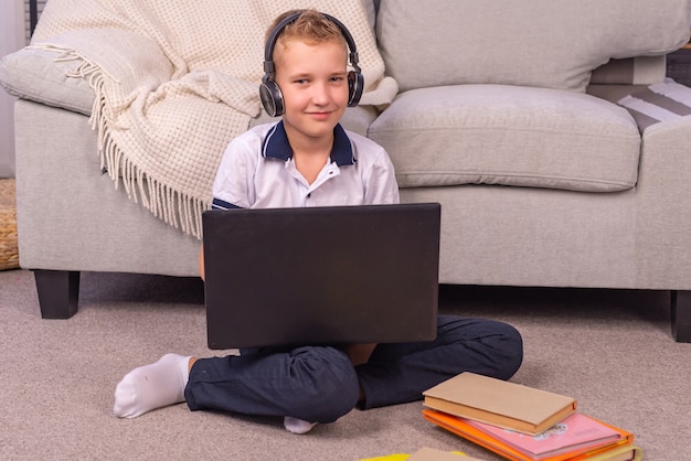 El colegial hace los deberes en una computadora portátil de aprendizaje en línea