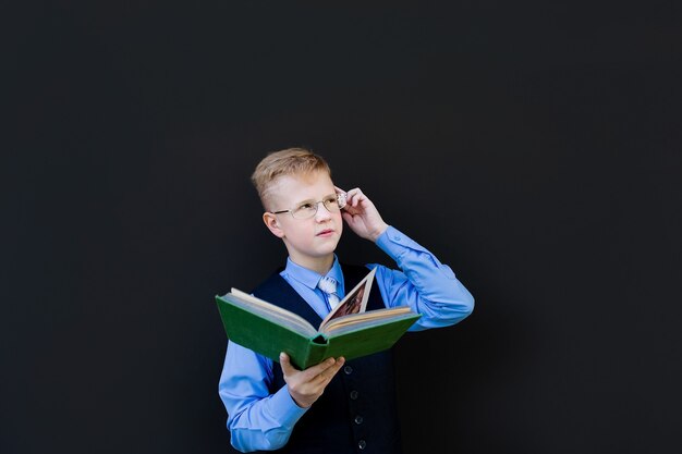 El colegial con un libro sobre un fondo negro