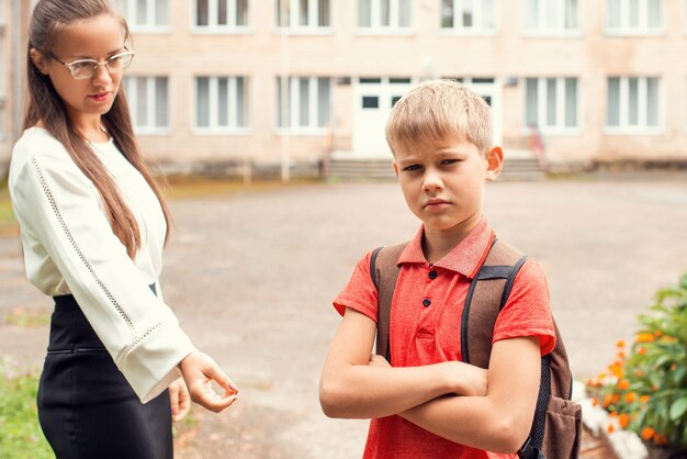 El colegial con mochila no quiere ir a la escuela