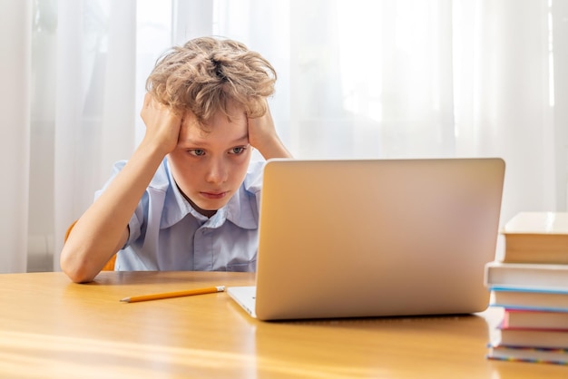 Colegial pensativo estudiando en línea