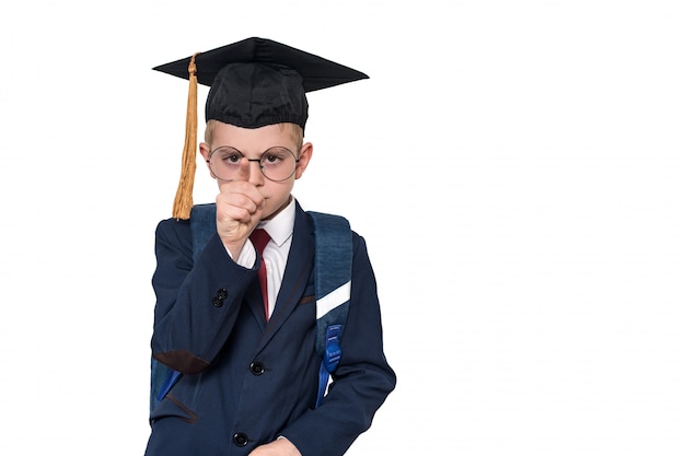 Un colegial serio con traje, anteojos y un sombrero académico señala con el dedo. Concepto de escuela Aislar