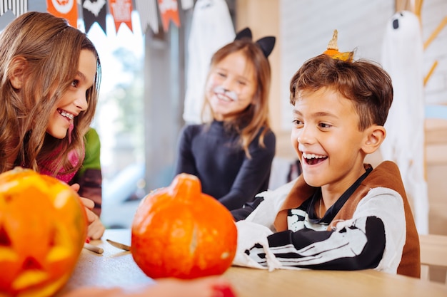 Colegial sonriente. Hermoso colegial sonriente que se siente increíble mientras usa el disfraz de esqueleto para la fiesta de Halloween