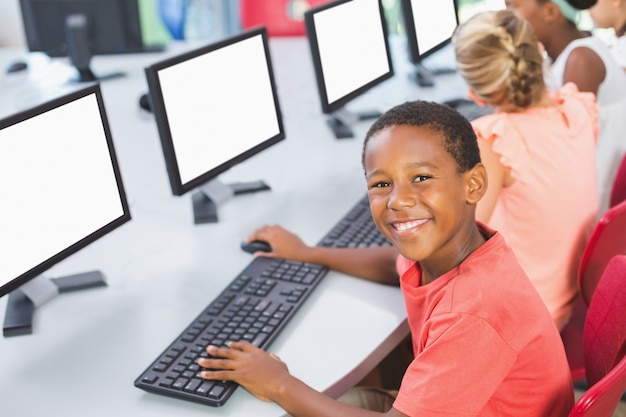 Colegial usando la computadora en el aula