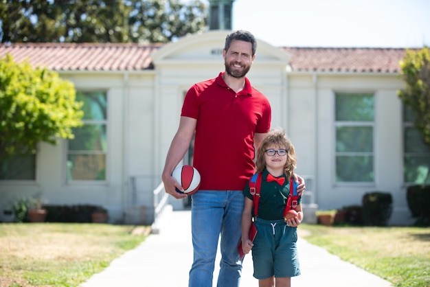 Colegial yendo a la escuela con el padre Escuela al aire libre