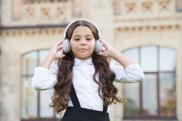 Colegiala alegre Colegiala relajante Concepto de infancia feliz Día internacional de los niños Canción feliz Ocio y descanso Peinado magnífico Alumno sonriente Éxito real Niño feliz al aire libre