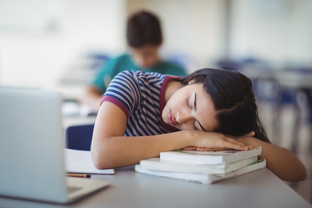 Colegiala cansada durmiendo en el aula