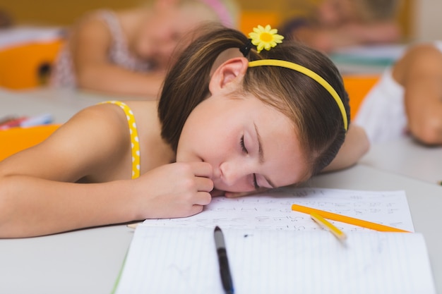 Colegiala durmiendo en el escritorio