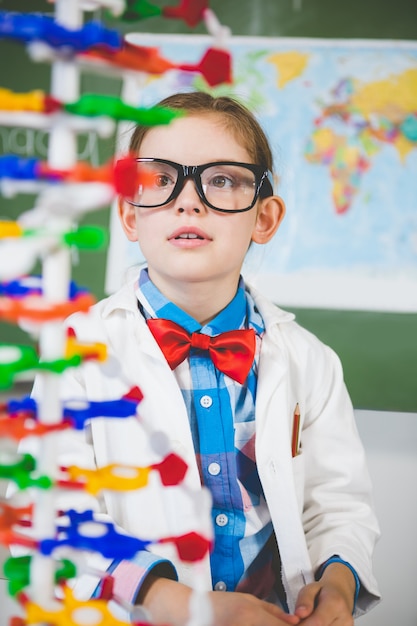 Colegiala ensamblando modelo de molécula para proyecto de ciencia en laboratorio