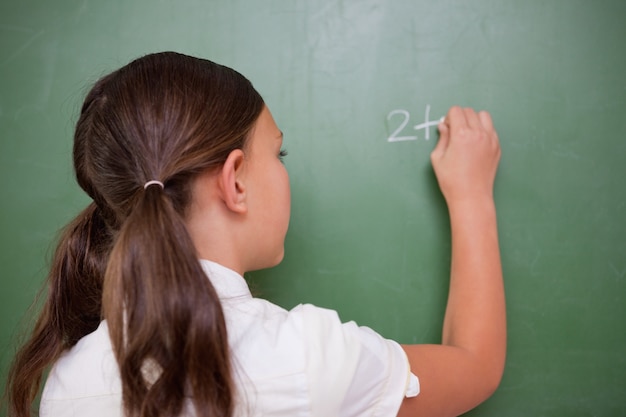 Colegiala escribiendo una adición