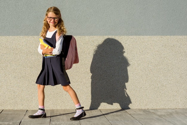 Una colegiala de la escuela primaria con cuadernos en la mano.