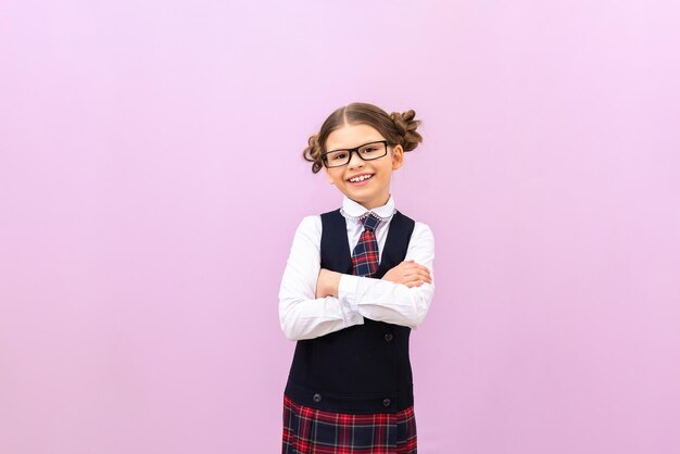 Una colegiala feliz y contenta mira a la cámara a un estudiante en un fondo aislado