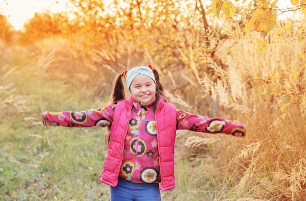 Colegiala feliz en huerto de manzanas de otoño