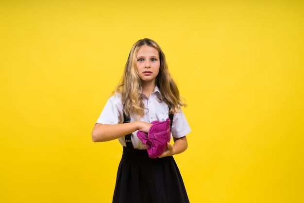 Colegiala feliz con lápices de colores y una caja de lápices en la mano