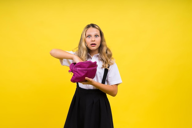 Colegiala feliz con lápices de colores y una caja de lápices en la mano