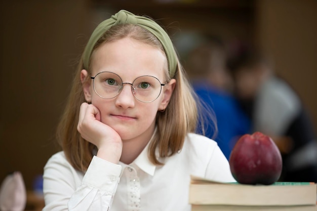 Colegiala con gafas en el escritorio