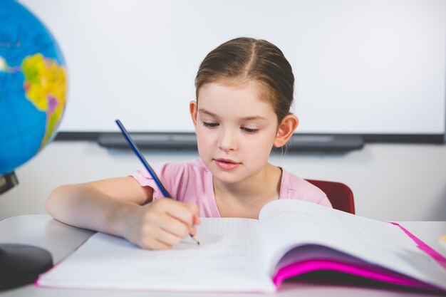 Colegiala haciendo la tarea en el aula